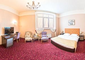 a bedroom with a bed and a desk and chairs at Hyde Park Hotel in Tver