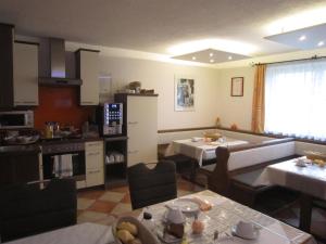 a living room with two tables and a kitchen at Frühstückspension Kibler in Sankt Georgen im Attergau
