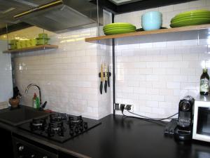 a kitchen counter with a stove and a microwave at Atlashouse in Riga