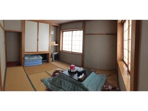 Kagura House في يوزاوا: غرفة معيشة مع أريكة وطاولة