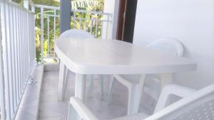 a white table and chairs on a balcony at Duplex La Rivière in Deshaies +23 photos