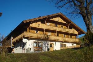 duży drewniany dom na szczycie wzgórza w obiekcie Scherntreinerhof w mieście Westendorf