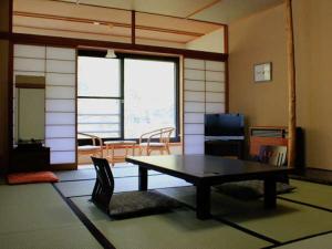 a room with a table and chairs in a room at Takaragawa Onsen Ousenkaku in Minakami
