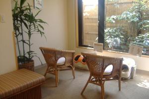 a room with two chairs and a bed and a window at Hotel Route-Inn Nagaoka Inter in Nagaoka