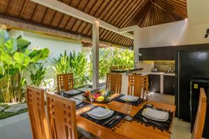 a kitchen and dining room with a table and chairs at Villa Beji in Seminyak