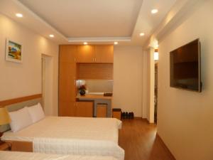 a hotel room with two beds and a kitchen at Lam Nghiep Do Son Hotel in Ðố Sơn