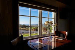 a dining room table with a large window with a view at Sky Harbour in Kaikoura