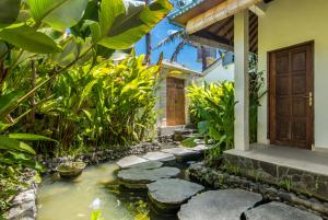 a koi pond in front of a house at Villa Beji in Seminyak