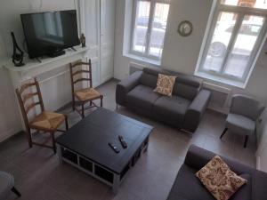 a living room with a couch and a tv at La Maison Boulonnaise in Boulogne-sur-Mer