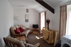 a living room filled with furniture and a tv at Kittiwake House in Port Erin