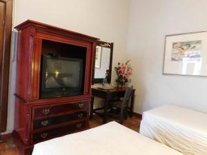 a bedroom with a tv in a wooden dresser at Hotel Urdiñola Saltillo in Saltillo