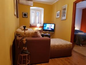 a bedroom with a couch and a tv in a room at Mili Apartament in Vela Luka