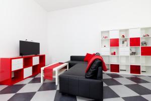 サンタニェッロにあるCasa Gecoのリビングルーム(黒いソファ、赤と白のキャビネット付)