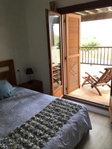 a bedroom with a bed and a balcony with a chair at Apartamento Valle Golf Resort in Baños y Mendigo