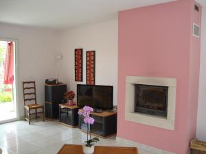 sala de estar con pared de color rosa y chimenea en Villa du Chene, en Siros