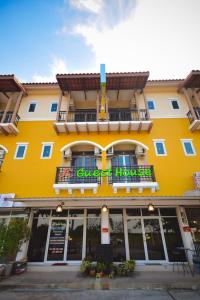 a yellow building with a sign on the front of it at JC Guesthouse @ Suratthani Airport in Surat Thani