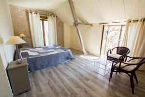 a bedroom with a bed and a chair in a room at Chambres d'Hôtes L'Oustralac in La Chapelle-Aubareil +7 photos