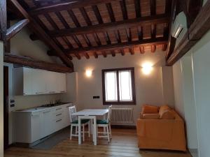 cocina y sala de estar con mesa y sofá en Alloggio Il Giuggiolo, en Bassano del Grappa