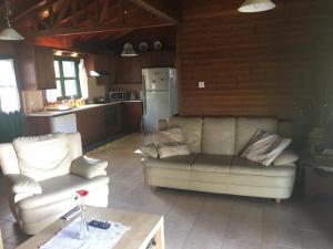 a living room with two couches and a kitchen at Koilani Village House in Koilani