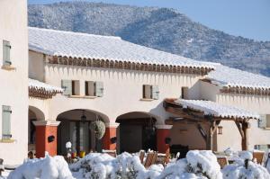 a building covered in snow with snow covered bushes at Mas La Jaina in Bargemon