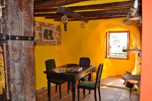 ein Esszimmer mit gelben Wänden sowie einem Tisch und Stühlen in der Unterkunft Rocky in Villajoyosa