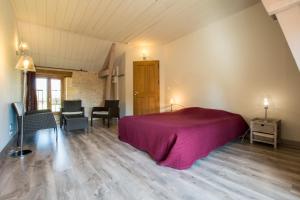 1 dormitorio con 1 cama, mesa y sillas en Chambres d'Hôtes L'Oustralac, en La Chapelle-Aubareil