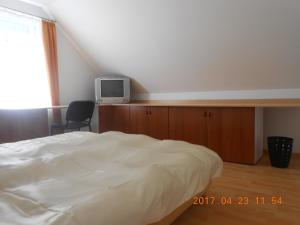 - une chambre avec un lit et une télévision sur une armoire dans l'établissement Boglárka Apartmanház, à Balatonfüred