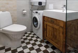a bathroom with a toilet and a sink and a washing machine at Aia Vacation Apartment in Pärnu +12 photos