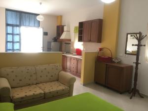 a living room with a couch and a kitchen at Apartments Villa Braho in Pogradec