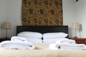 a room with a bed with towels on it at Old Court Hotel & Apartments in Symonds Yat