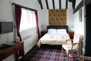 a bedroom with a bed and a desk and a tv at Old Court Hotel & Apartments in Symonds Yat