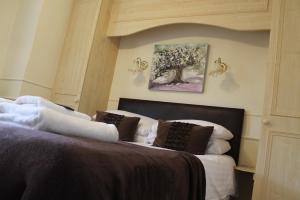a bedroom with a bed and a painting on the wall at Old Court Hotel & Apartments in Symonds Yat