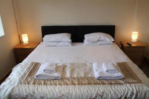 a bedroom with a bed with towels on it at Old Court Hotel & Apartments in Symonds Yat