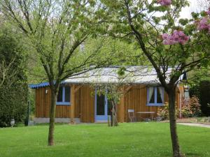 a wooden cabin with a yard with two trees at Les Petites Aunettes in Vaubadon