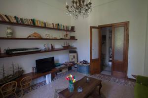 a living room with a table and a tv and shelves at Villa Daura in Riccò del Golfo di Spezia