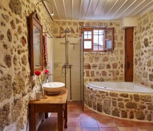 a bathroom with a large tub and a sink at Helios Garden Boutique Apartments in Rhodes Town