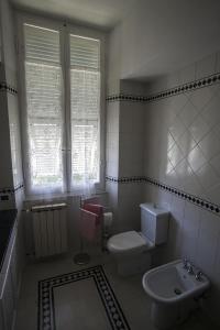 a white bathroom with a toilet and a sink at Villa Daura in Riccò del Golfo di Spezia