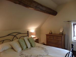 um quarto com uma cama, uma cómoda e uma janela em Pillarbox Cottage em Matlock