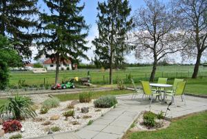 a patio with a table and chairs and a field at Das Sonnengleis in Lutzmannsburg