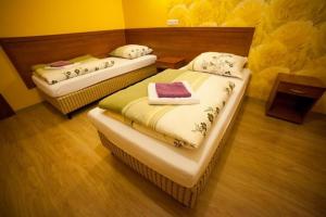 - 2 lits dans une chambre aux murs jaunes dans l'établissement Hotel Heaven, à Chabsko