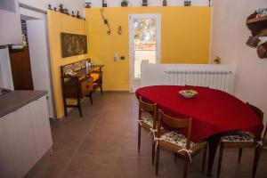 a kitchen and dining room with a red table and chairs at Tenuta Sperlinga - Il Campanile in Santa Flavia +24 photos
