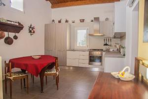 a kitchen with a table with a red table cloth at Tenuta Sperlinga - Il Campanile in Santa Flavia
