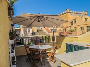 a table and chairs with an umbrella on a balcony at Tenuta Sperlinga - Il Campanile in Santa Flavia