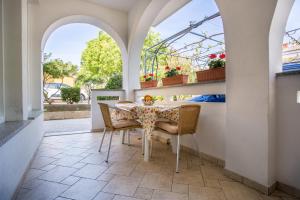a dining room with a table and chairs and windows at Apartments Kraljić in Baška