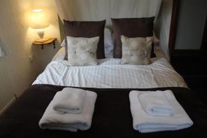 a bed with towels and pillows on it at Old Court Hotel & Apartments in Symonds Yat