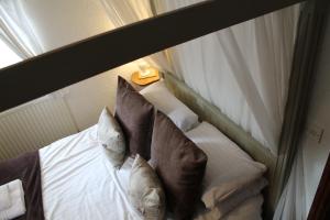 a bed with pillows on it in a room at Old Court Hotel & Apartments in Symonds Yat