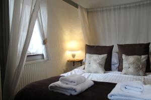 a bedroom with two beds with towels on them at Old Court Hotel & Apartments in Symonds Yat