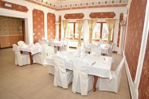 une salle à manger avec des tables et des chaises blanches dans l'établissement Hotel Heaven, à Chabsko