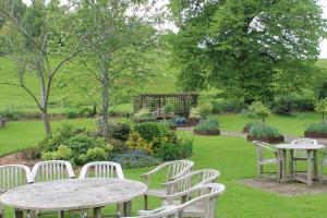 a group of tables and chairs in a garden at Old Court Hotel & Apartments in Symonds Yat