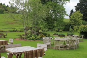 a picnic table and chairs in a yard with a field at Old Court Hotel & Apartments in Symonds Yat